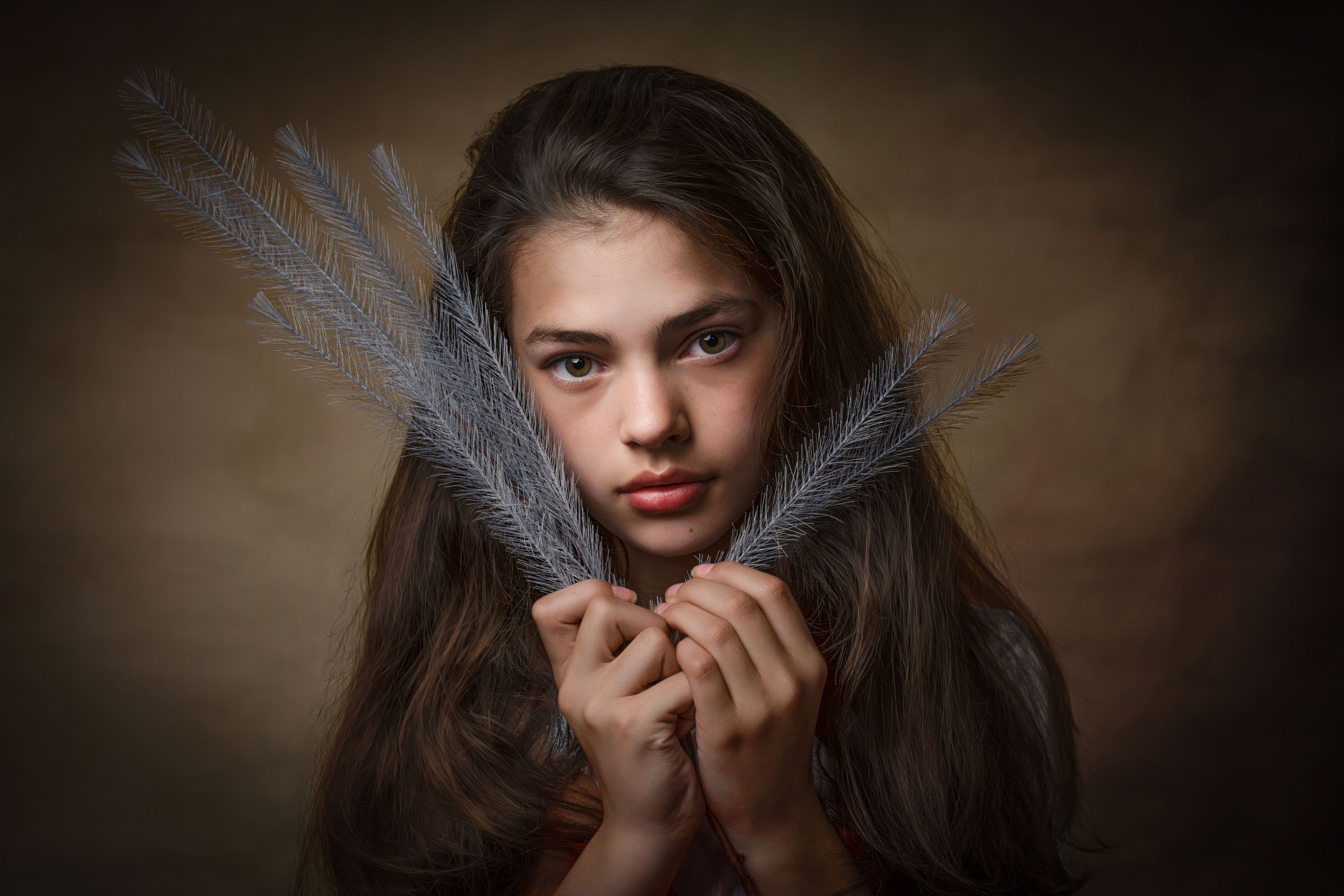 Fine art portrait — girl holding silver feathers