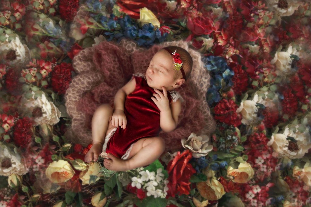 Fine art newborn portrait — baby among flowers