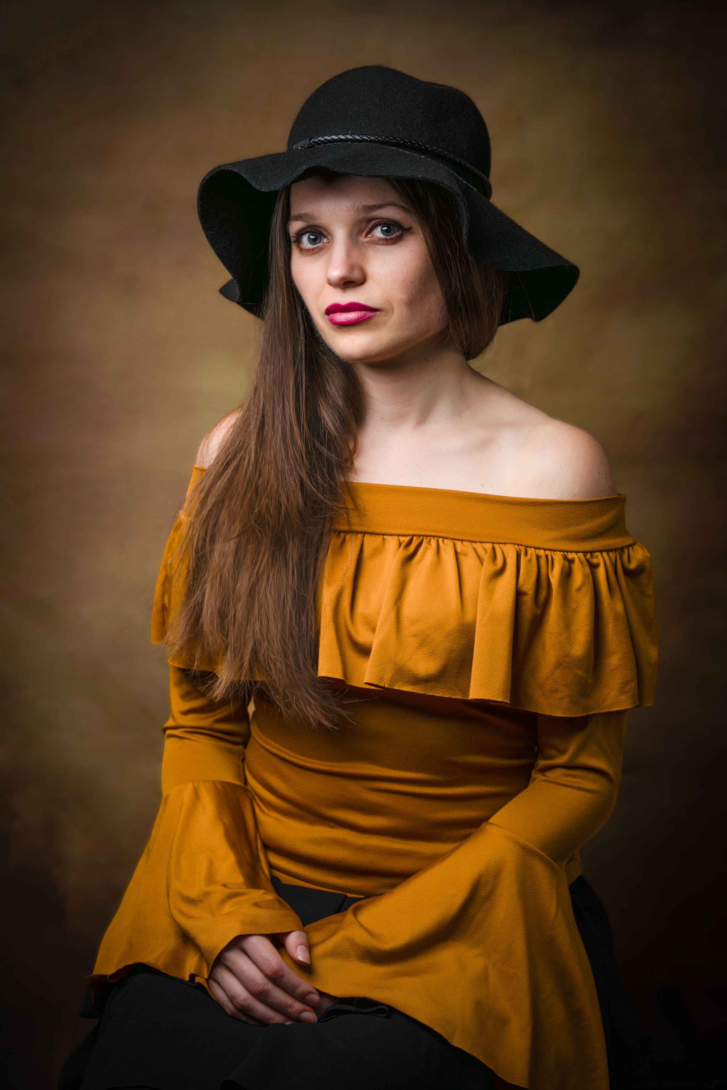 Fine art portrait — woman in a mustard dress and black hat